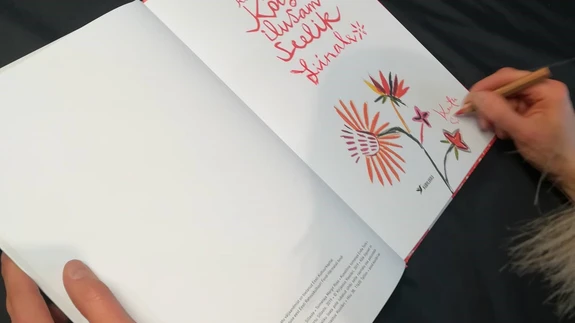 Raamatu autor teosele oma signatuuri kirjutamas.